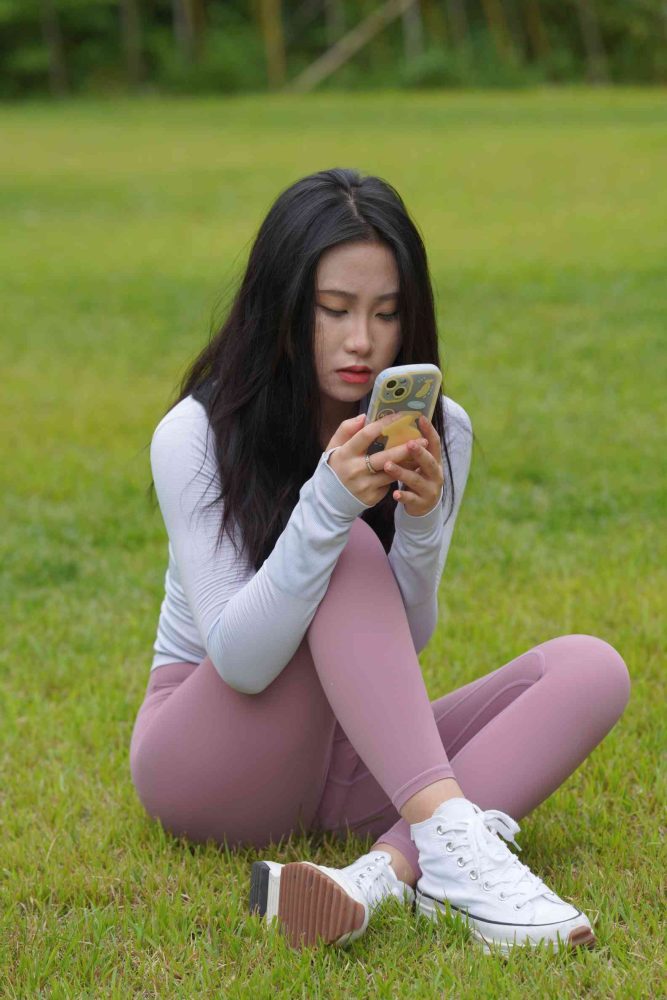 图片[1]-坐在草地玩手机的瑜伽姑娘【733P】04012-达塔图库